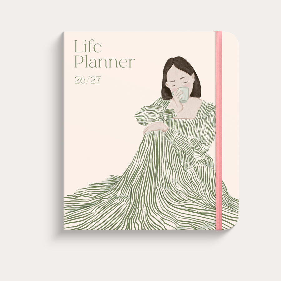 Life Planner Decor Green Flow 26/27 med ljusrosa omslag, illustrerad kvinna i grön klänning och rosa resår